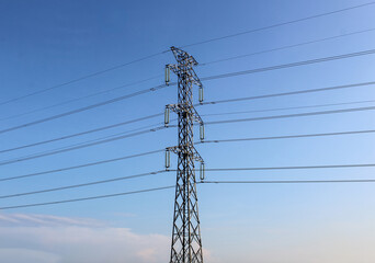 Selective focus of High voltage towers or power line tower with a background of bright blue sky...