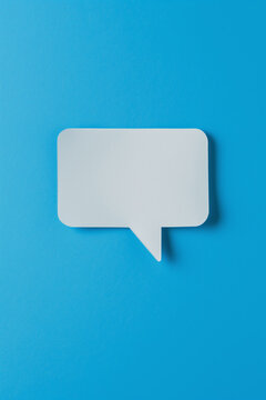 A white paper with a speech bubble on a blue background. Concept of emptiness or lack of communication