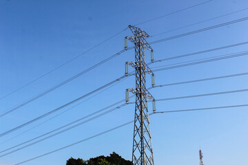Selective focus of High voltage towers or power line tower with a background of bright blue sky...