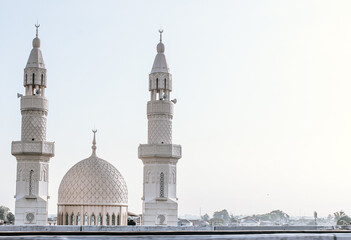 selective focus white mosque dome with two minarets beside it during sunset