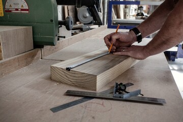 person measuring with a ruler and marking out with a pencil