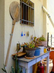 Quaint corner with rustic items and plants by a window, exuding a cozy vintage vibe perfect for quaint-themed visuals.