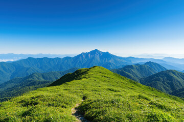 A picturesque view of a lush green mountain range under a clear blue sky, perfect for nature lovers and outdoor enthusiasts capturing serene landscapes.