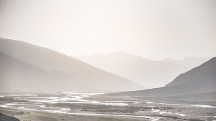 Silhouette of mountain ranges, panorama of Wakhan corridor and Panj river in valley in Pamir in Tajikistan Tien Shan mountains, morning at dawn minimalistic landscape for background