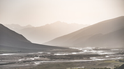 Silhouette of mountain ranges, panorama of Wakhan corridor and Panj river in valley in Pamir in Tajikistan Tien Shan mountains, morning at dawn minimalistic landscape for background