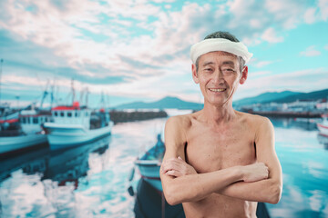 Fototapeta premium 笑顔で腕を組む高齢の漁師