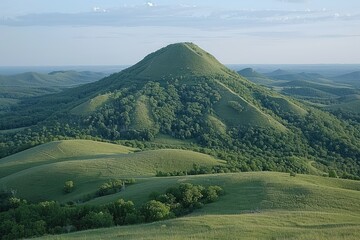Rolling Green Hills and a Mountain Peak in a Foggy Landscape