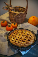 Pie and orange fruits on a wooden table