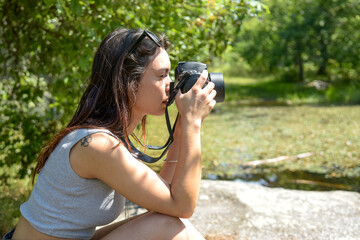 Caucasian woman taking pictures in the nature