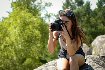 Caucasian woman taking pictures in the nature