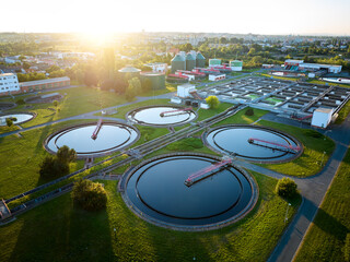 Aerial view of wastewater treatment plant at sunrise, ideal for illustrating sustainable water management, environmental engineering, and modern infrastructure in urban planning contexts.