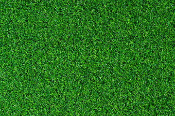 Fototapeta premium Artificial green grass mat, top view. Texture. Artificial turf, surface made of synthetic fibers. Flat green grass texture background. Short artificial grass golf surface