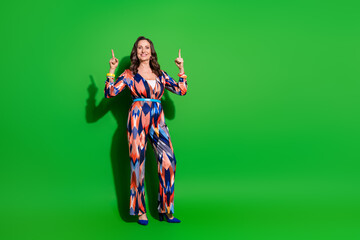 Full length photo of adorable lovely woman wear colorful overall showing two fingers up empty space isolated green color background