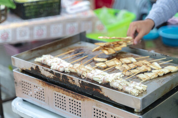 Grilled skewers on metal grill over gas stove.