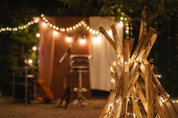 Cozy outdoor evening setup with string lights and logs.