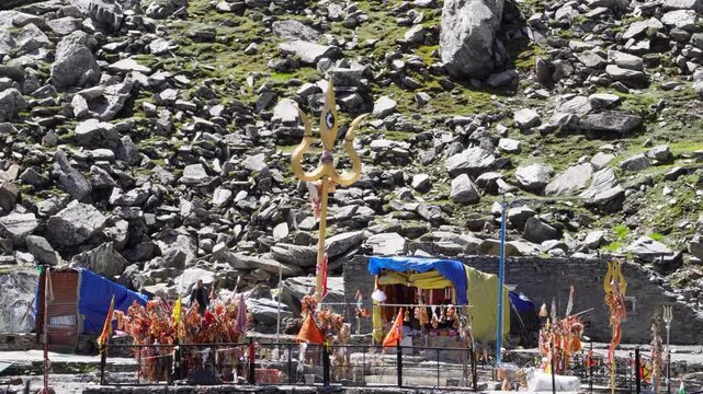 Religious red cloths (chunri) and tridents (trishul), symbols of Lord Shiva, against Kailash Parvat during the Mani Mahesh Kailash Yatra, a Hindu and Buddhist pilgrimage.