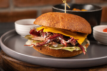 Closeup on portion of brisket burger with potato wedges