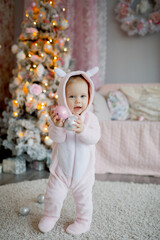 child sitting near christmas tree