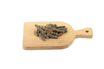 Small cutting board with pile of Long or Pippali pepper fruits on white background.