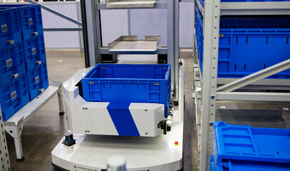 Autonomous robot picking materials from multi-layer rack in modern industrial warehouse.