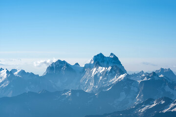 highlands landscape, mountain range in blue haze, Mount Ushba in Georgia, view from Mount Elbrus