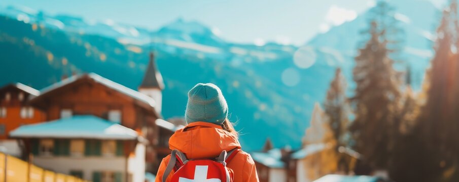 Person looking at alpine village and mountains. Switzerland tourism concept. Image for travel poster and promotional banner.