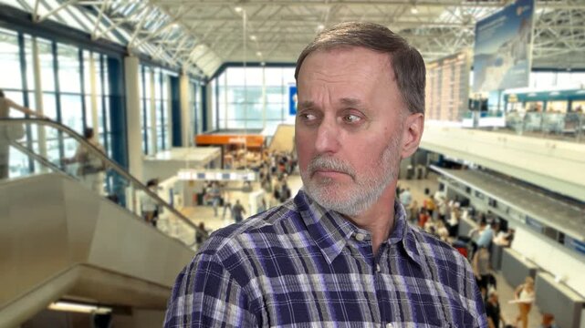 Portrait of senior caucasian man anvying someone. Suspicious and disapproval look. Mall interior in the background.