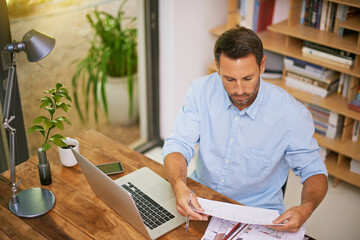 Paperwork, architecture and man in home office with laptop, floor plan or professional contractor...