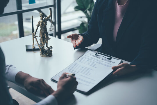 Legal Counsel and Guidance: A client and lawyer meticulously review a contract agreement, seeking justice and clarity in the realm of law. 