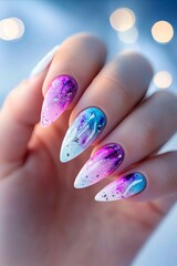 A woman's hand holding a purple and blue manicure with a galaxy design on it