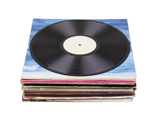 Fototapeta premium Vinyl record on a stack paper envelopes. Analog sound. Classic audio. Isolated on white