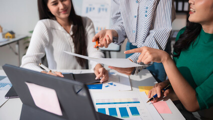 Obraz premium Three businesswomen working together on new project analyzing financial data charts and graphs on the table