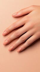 Fototapeta premium A close-up of a well-manicured hand on a soft beige surface, showcasing natural elegance and beauty.