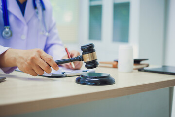 The hammer of justice is a law protecting doctors in diagnosing patients and leading to their death. Hospital insurance considers safety in judgment with lawyers, judges, courts, copy space.