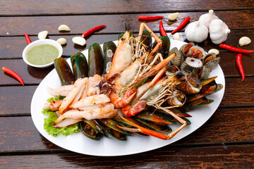 Seafood plate with shrimp shellfish crab squid cockle spotted babylon with seafood sauce chili...
