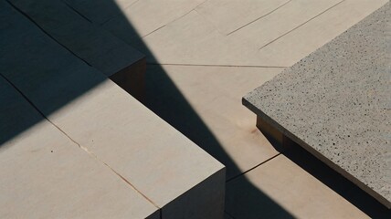 Fototapeta premium A concrete bench casting a shadow, highlighting its texture and form in a serene outdoor setting