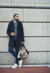 Thinking, bag and businessman at wall space for fashion winter style or travel on morning commute...