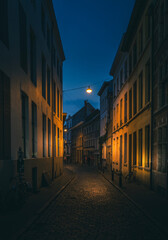 A dark cobblestoneed street taken at dusk in Ghent