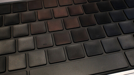 Obraz premium Closeup of a sleek, modern laptop keyboard with dark keys in low light. Perfect for tech, business, or productivity concepts.