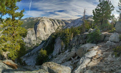 A mountain range with a clear blue sky and a few trees