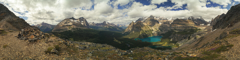 A panoramic view of a mountain range with a blue lake in the foreground
