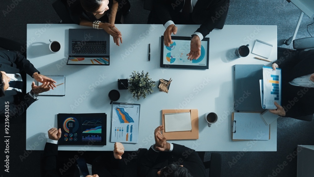 Poster top down aerial view of smart manager pointing at financial graph on whiteboard while diverse busine