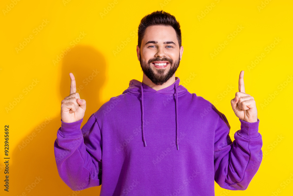 Poster Photo of positive stylish nice man wear purple clothes demonstrate empty space banner isolated on yellow color background