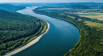 Aerial view of the wide river in an autumn forest, showing its winding path through nature