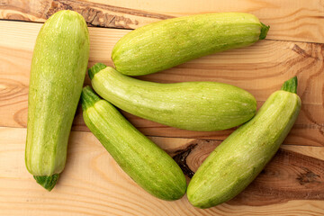 Several ripe zucchini on a wooden table, macro, top view.