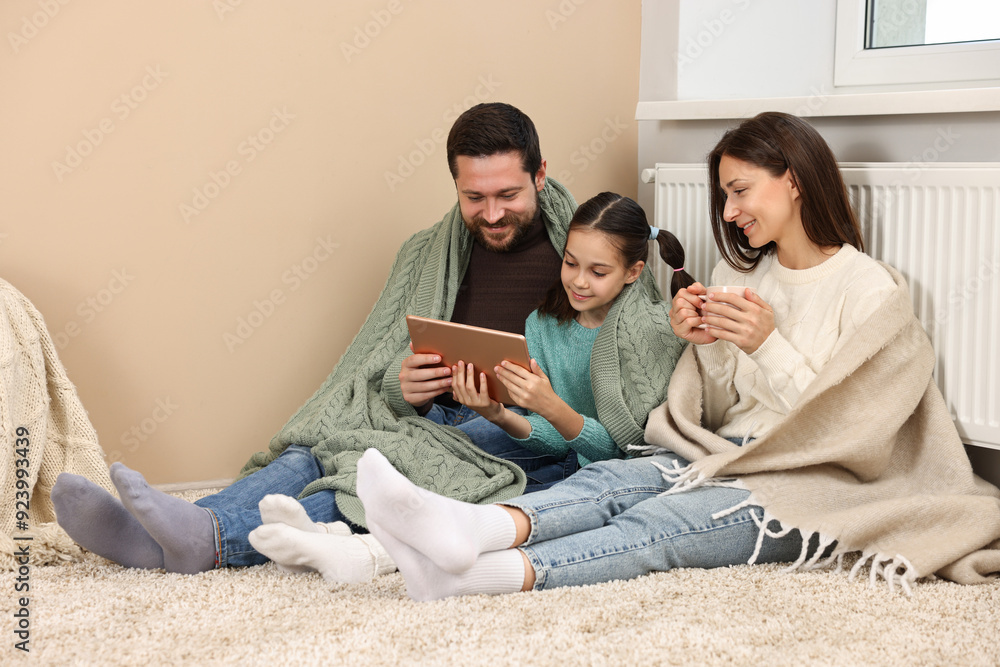 Wall mural Happy family with tablet near heating radiator at home