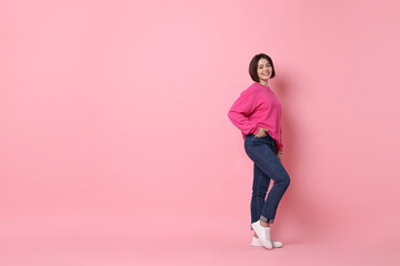 Smiling woman posing on pink background. Space for text