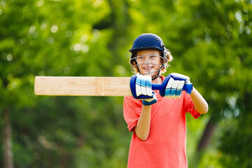 Kids playing cricket in summer park
