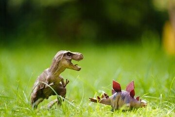 Child playing with dinosaur toy in sunny garden