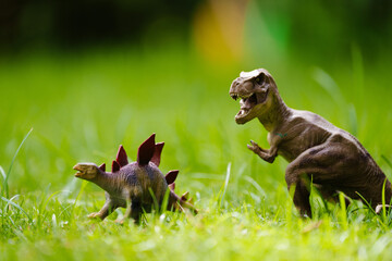 Child playing with dinosaur toy in sunny garden
